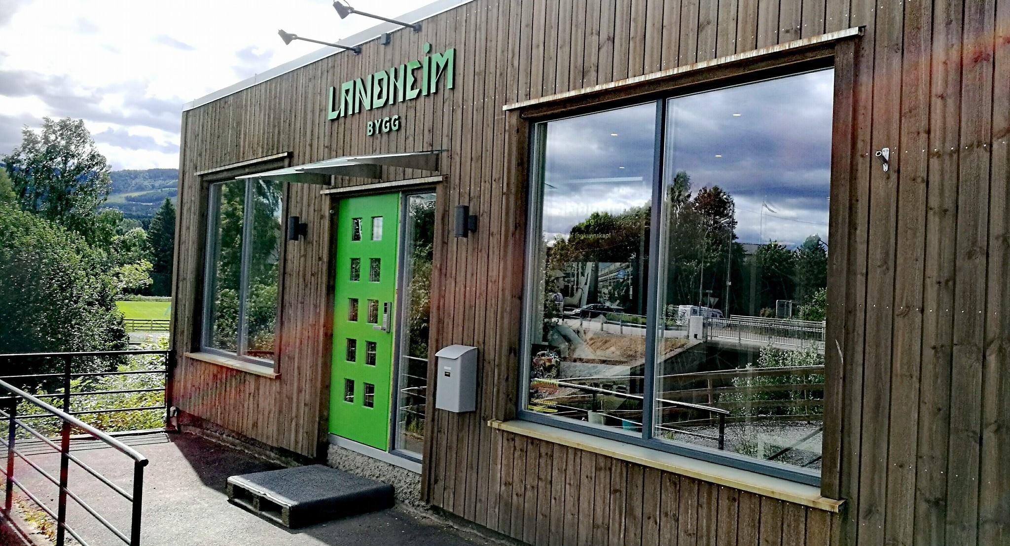 The Landheim Bygg office: dark timber cladding, big windows and a bright green door
