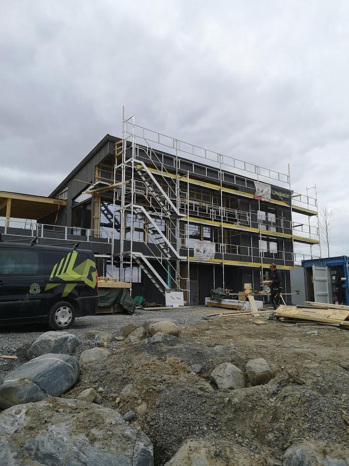 A new three-storey building in scaffolding on a rocky site