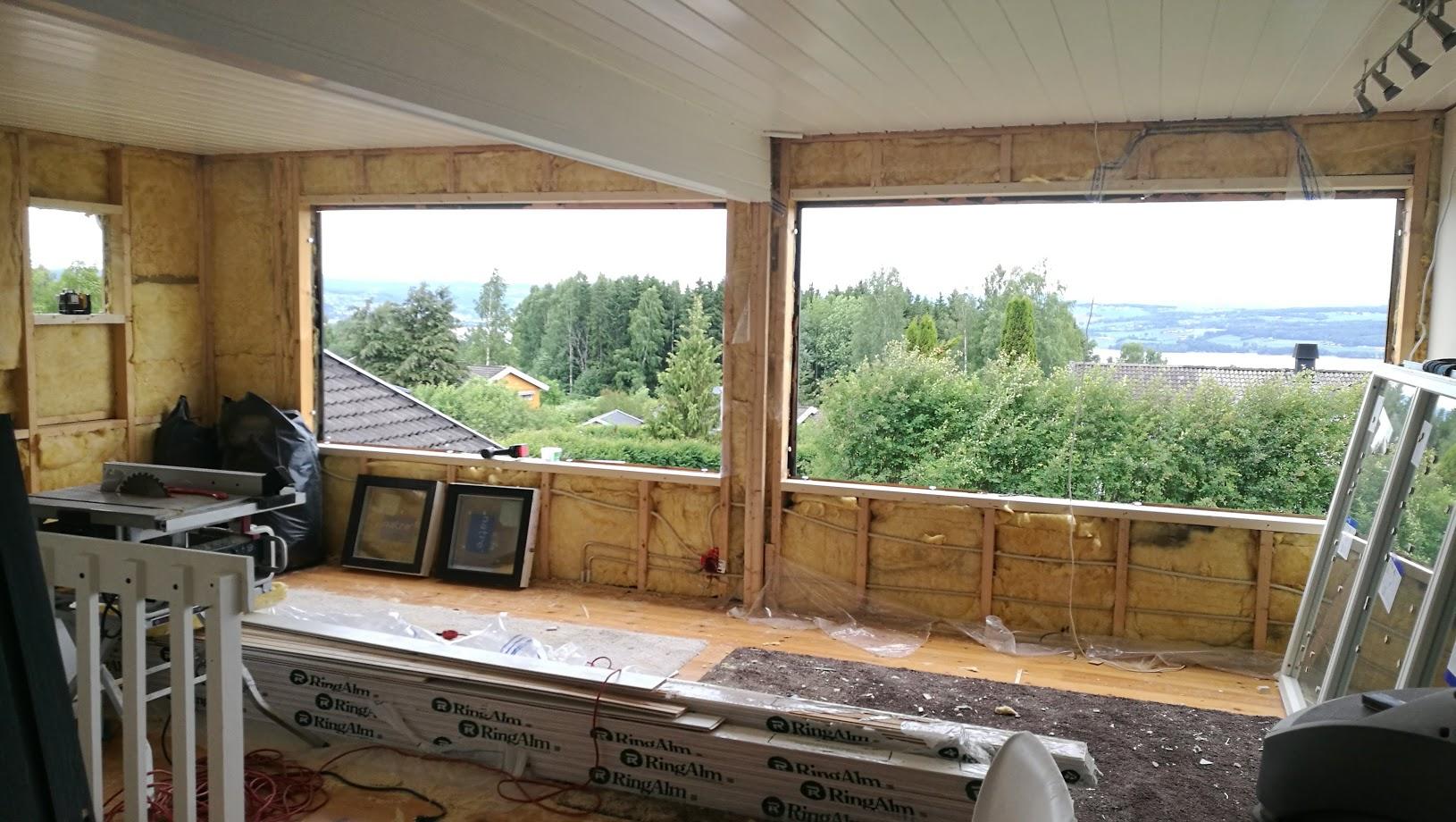 A room under renovation, with large windows looking out over a lake